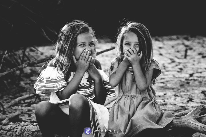 دو دختر بچه دوست سیاه و سفید در حال خندیدن