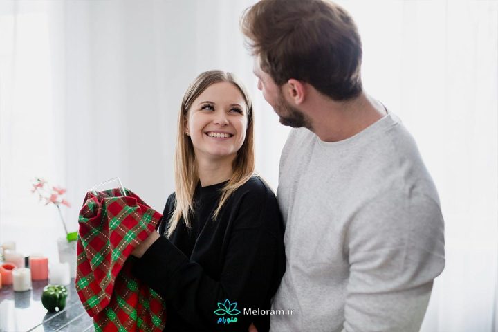 زنی که در حال تمیز کردن لیوان برای همسر خود است.