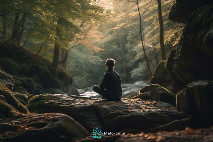 زنی بر روی یک تخته سنگ در طبیعتی سبز و زیبا در حال دعا کردن و تمرکز.