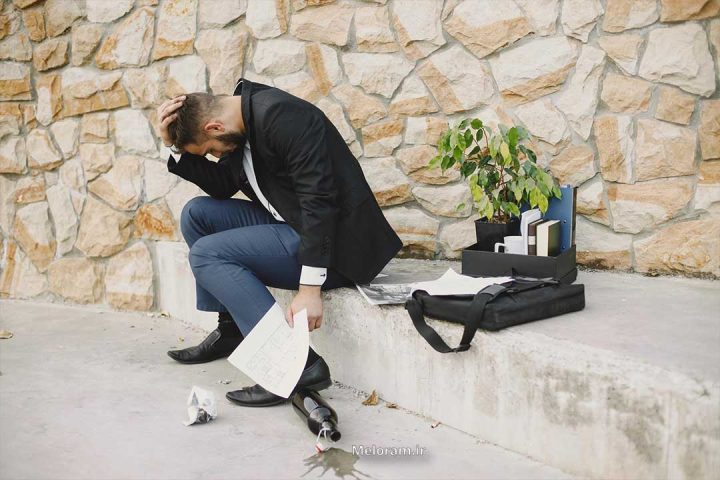 مردی با لباس رسمی که در کنار یادگاری های کسی که از دستش داده است ناراحت است.