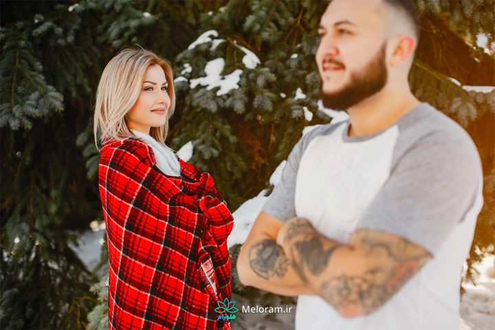 زنی که در فضای برفی با علاقه پنهانی به یک مرد ریشو نگاه می کند.